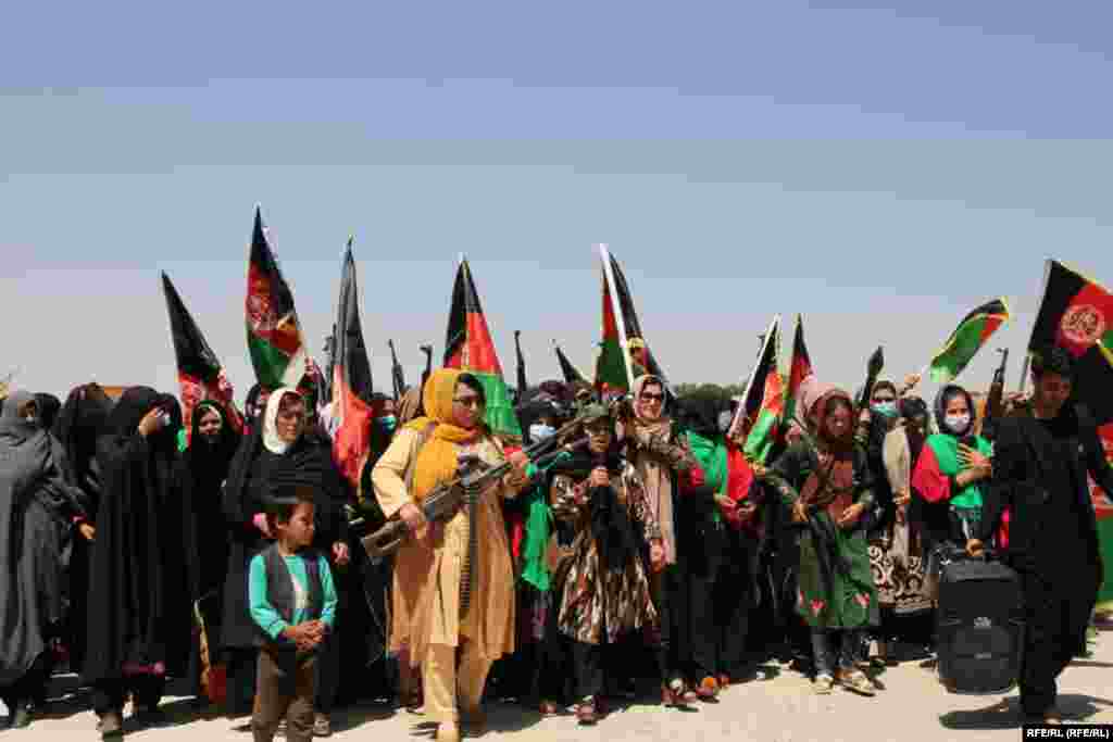 Women carry automatic weapons as they march in opposition to the Taliban in the central-western Ghor Province on July 6.