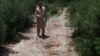 A plainclothes police officer indicates the bloody spot where popular Pakistani blogger and social-media activist Muhammad Bilal Khan was killed in Islamabad on June 16.