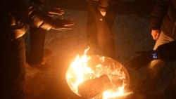 Жители Киева, оставшиеся без отопления, обогреваются у огня