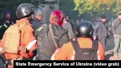 Rescuers help a wounded man after a Russian drone strike on a hospital in Ukraine's Sumy region on September 28.