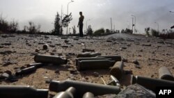 Spent bullet shells litter the ground as a member of the Islamist-linked militia of Misurata walks past following three days of battles in the area of Tripoli's international airport on August 21. 