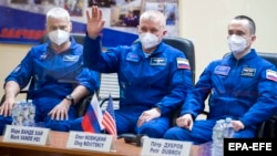 Членовите на екипажот на Меѓународната вселенска станица, астронаутот Марк Ванде Хеи од НАСА и космонаутите Олег Новицки и Пјотр Дубров од Роскосмос на прес-конференција во космодромот Бајконур во Казахстан на 8 април.