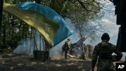 Ukrain esgerleri 12-nji maýda Bahmutyň golaýynda top atýarlar.