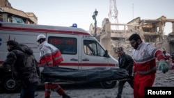 Медици носят носилка в Техеран, след удар по полицейска сграда, 3 март 2026 г.