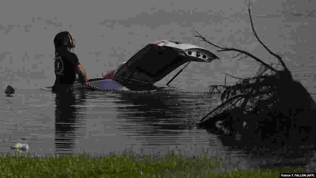 Čovjek pomoću užeta pokušava izvući potopljeni automobil, LaPlace, Louisiana.
