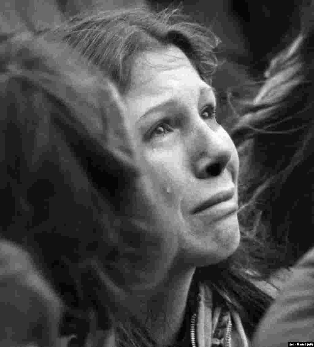 Женщина плачет на траурном митинге у церкви Святой Троицы в Бостоне (США) во время десятиминутного молчания в честь Джона Леннона, 14 декабря 1980 года. Почтить память убитого в Нью-Йорке музыканта пришли порядка 2 тысяч человек