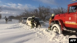 Rescuers help drivers trapped in the Mykolayiv region following heavy snowfall on November 27.