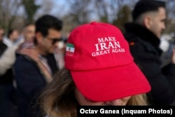O femeie poartă o șapcă roșie cu mesajul „Să facem Iranul măreț din nou”, la evenimentul din parcul Herăstrău, București, 1 martie 2026.