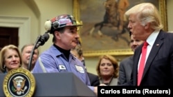 Michael Nelson szénbányász ráz kezet Trump elnökkel 2017. február 17-én egy sajtóeseményen, miután a kormány épp eltörölt egy, a természetes vizek védelméért hozott, de a szénbányászat számára hátrányos szabályozást. 