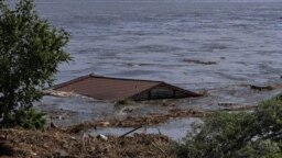 The roof of a house is seen in the Dnieper River, which flooded after Ukraine's Nova Kakhovka dam was breached on June 6.