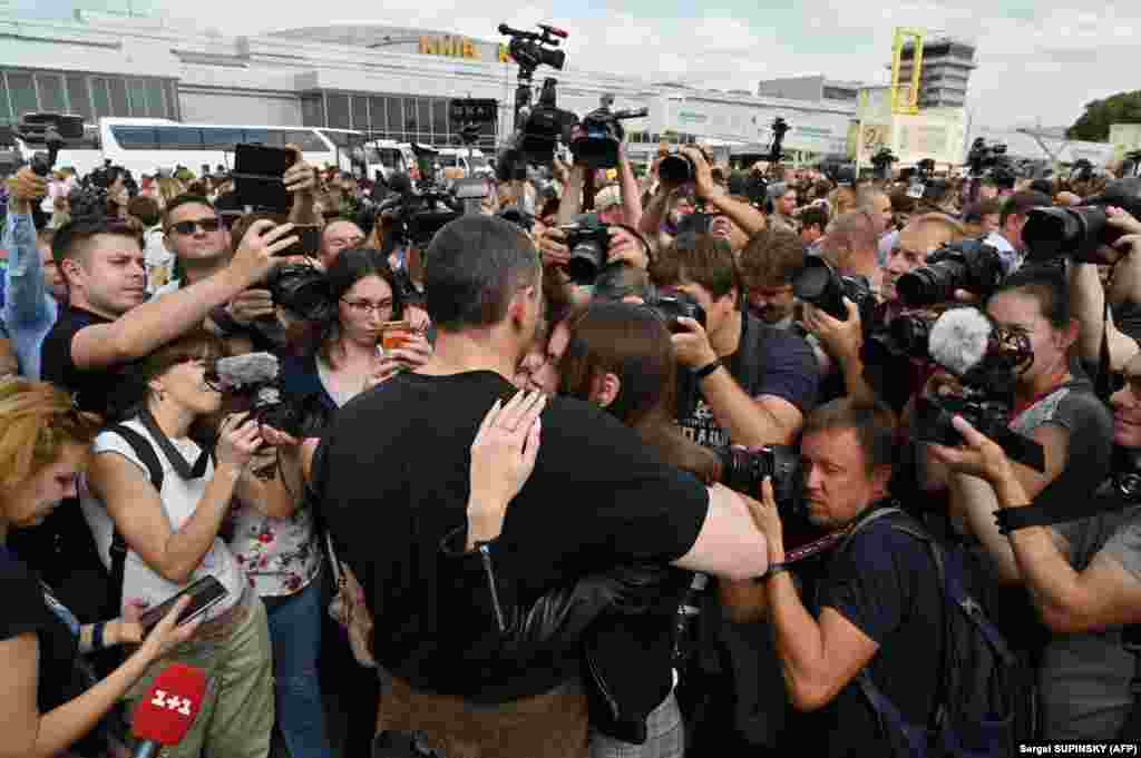 Reporters surround Ukrainian film director Oleh Sentsov as he hugs his daughter, Alina Sentsova, at Boryspil International Airport outside Kyiv.