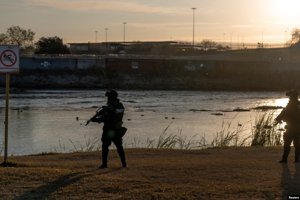 Oficerë të policisë duke patrulluar përgjatë bregut të lumit Rio Grande.