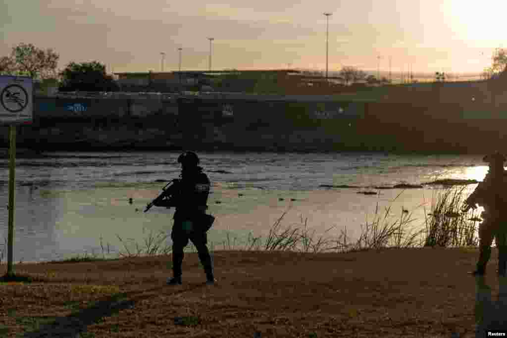 Oficerë të policisë duke patrulluar përgjatë bregut të lumit Rio Grande.