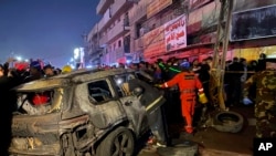 Ekipet e shpëtimit pranë një veture të djegur nga një sulm amerikan me dron në lindje të Bagdadit, Irak, e mërkurë, 7 shkurt 2024.