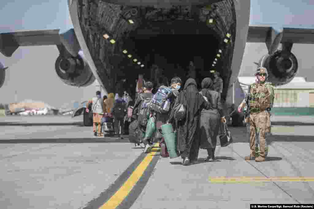 Families begin boarding a U.S. Air Force transport plane during evacuations at Hamid Karzai International Airport.