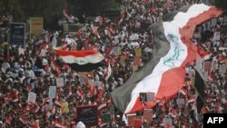 Thousands of Iraqis, waving national flags, take to the streets in central Baghdad on January 24.