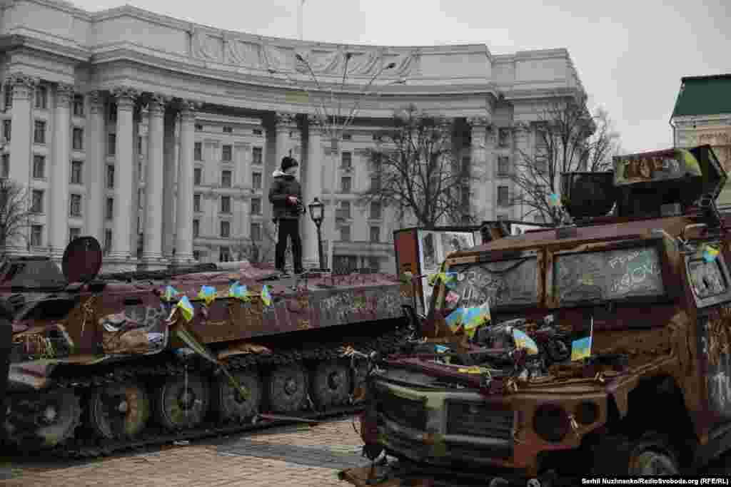 Хлопчик стоїть на знищеній російській військовій техніці, виставленій на Михайлівській площі в Києві. Січень 2025 року