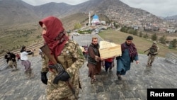 People carry the coffins of victims who died in what the Taliban government said was a Pakistani air strike on a drug rehabilitation center, during a mass burial in Kabul on March 18. 