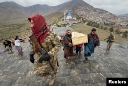 People carry the coffins of victims who died in what the Taliban government said was a Pakistani air strike on a drug rehabilitation center, during a mass burial in Kabul on March 18.
