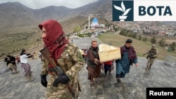 Njerëzit mbajnë arkivolet e viktimave që vdiqën në atë që qeveria talebane e quajti sulm ajror pakistanez në një qendër rehabilitimi, gjatë një varrimi masiv në Kabul më 18 mars.