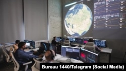 Инженеры и диспетчеры полета контролируют телеметрию, орбитальные траектории и сетевые данные спутника «Рассвет»