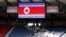 Spectators sit in the stands under the proper North Korean national flag ahead of their women's Group G football match against Colombia.