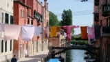 Laundry hangs on clothes lines strung above street between apartment buildings Italy's lockdown measures continue to prevent the spread of coronavirus disease (COVID-19) in Venice