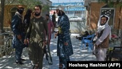 Taliban fighters stand guard at the entrance of the Wazir Akbar Khan mosque in Kabul on September 17.