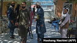 Taliban fighters stand guard at the entrance to a mosque in Kabul on September 17. 