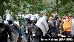 Rohamrendőrök egy migránsok által lakott sátortábornál Litvániában 2021. augusztus 2-án