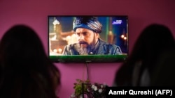 A family watches the Turkish drama series Dirilis: Ertugrul on Pakistani TV during the holy month of Ramadan in Islamabad.