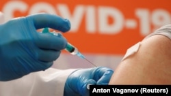 A person receives a dose of Sputnik V vaccine at a vaccination center in a shopping mall in St. Petersburg.