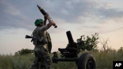 Український військовий 3-ї ДШБ веде вогонь зі 122-мм міномета по російських позиціях на передовій поблизу Бахмуту, 2 липня 2023 року