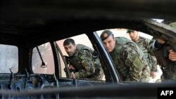 FILE: Afghan National Army (ANA) soldiers inspect a vehicle which was used in an attack in Farah.