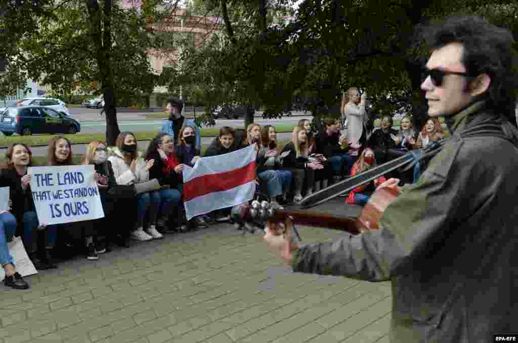 Students sit and sing songs near the entrance of their university in Minsk to show their solidarity with classmates who have been detained by state security forces.