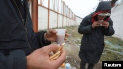 Disa migrantë duke u ushqyer në një fabrikë të braktisur, afër kufirit të Serbisë me Kroacinë.