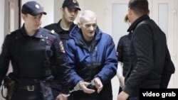 Юрий Дмитриев в окружении полицейских