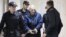 Юрий Дмитриев в окружении полицейских