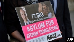 An interpreter holds a petition signed by over 70,000 people calling for asylum for Afghan interpreters who served the British Army in 2013.