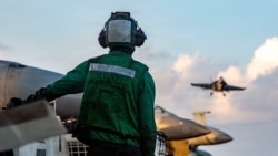 A US sailor observes flight operations during Operation Epic Fury. The US military is enforcing a blockade of the Strait of Hormuz to cut off ships from using Iranian ports. 
