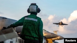 A US sailor observes flight operations during Operation Epic Fury. The US military is enforcing a blockade of the Strait of Hormuz to cut off ships from using Iranian ports. 