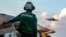 A US sailor observes flight operations during Operation Epic Fury. The US military is enforcing a blockade of the Strait of Hormuz to cut off ships from using Iranian ports. 