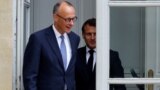 French President Emmanuel Macron walks with Germany's newly elected chancellor, Friedrich Merz, at the Elysee presidential palace in Paris on May 7.