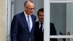 French President Emmanuel Macron walks with Germany's newly elected chancellor, Friedrich Merz, at the Elysee presidential palace in Paris on May 7.