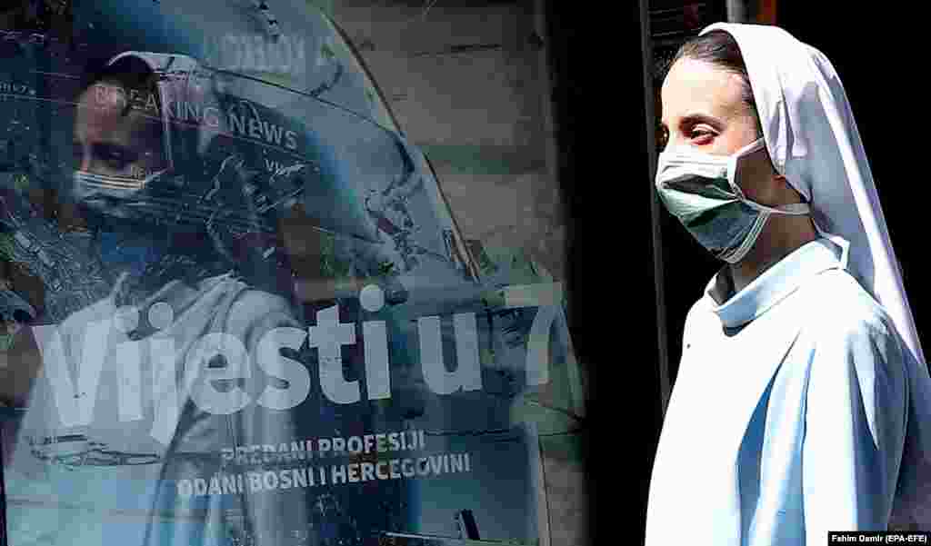 A nun wearing a protective face mask walks in a street in Sarajevo, Bosnia-Herzegovina. (epa-EFE/Fehim Demir)