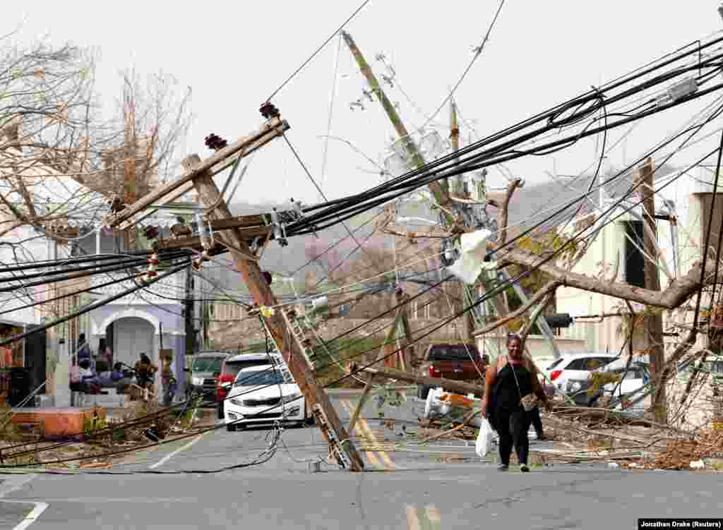 Residents and cars make their way around and under obstacles blocking a main road nearly a week after Hurricane Maria raked the island in Frederiksted, St. Croix, U.S. Virgin Islands, on September 26. (Reuters/Jonathan Drake)