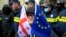 A woman with the EU and Georgian flags stands in front of police blocking a street during a an opposition rally in Tbilisi. (file photo)
