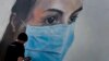 BELGIUM -- Graffiti artist Bram De Ceurt works on a street graffiti piece of a nurse with a mouth mask to protect against coronavirus in Antwerp, Belgium, Thursday, March 26, 2020. 