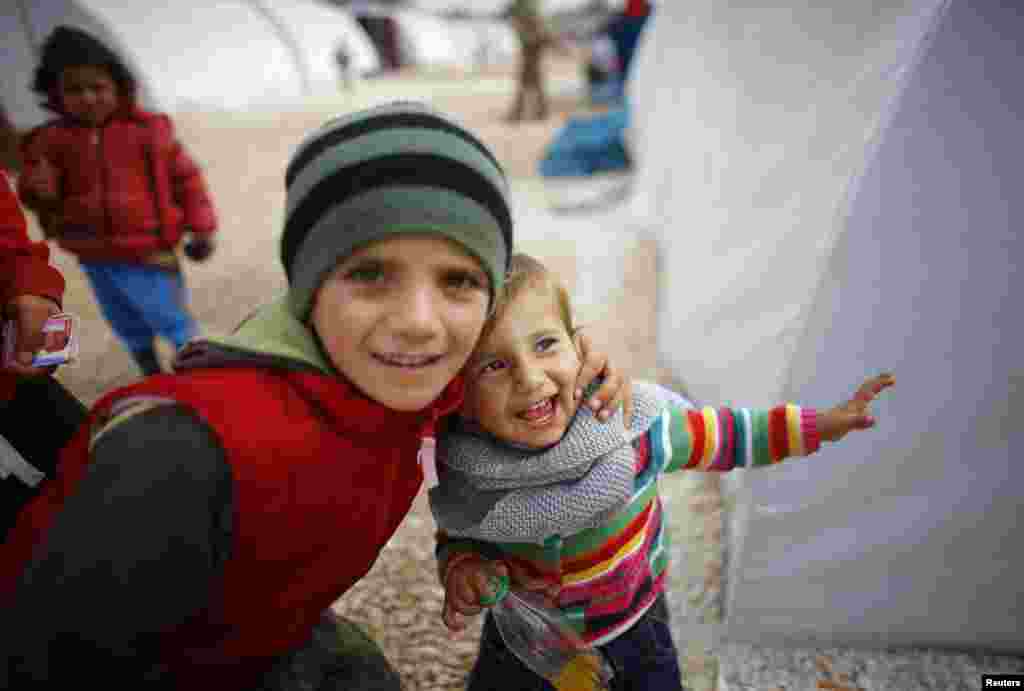 Kurdish refugee children from the Syrian town of Kobani smile as they play in a refugee camp in the border town of Suruc, Sanliurfa Province, Turkey. (Reuters/Osman Orsal)