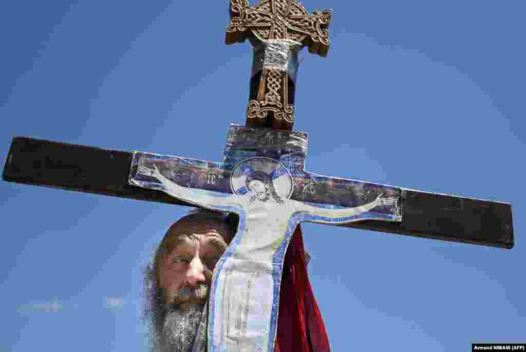 A Serbian man holds a crucifix at the same commemoration in Gazimestan. (AFP/Armend Nimani)